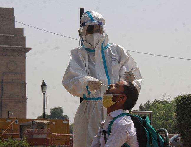 New Delhi: Health worker collects swab sample testing for Covid-19 at India Gate in new Delhi on Saturday March 27, 2021.(Photo: Wasim sarvar/IANS)