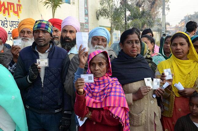 Amritsar: People holding their identification cards, stand in a queue to cast their votes, during the Punjab assembly elections, on the outskirts in Amritsar, Sunday, Feb. 20, 2022. on Sunday February 20, 2022.(Photo:IANS/Pawan Sharma)