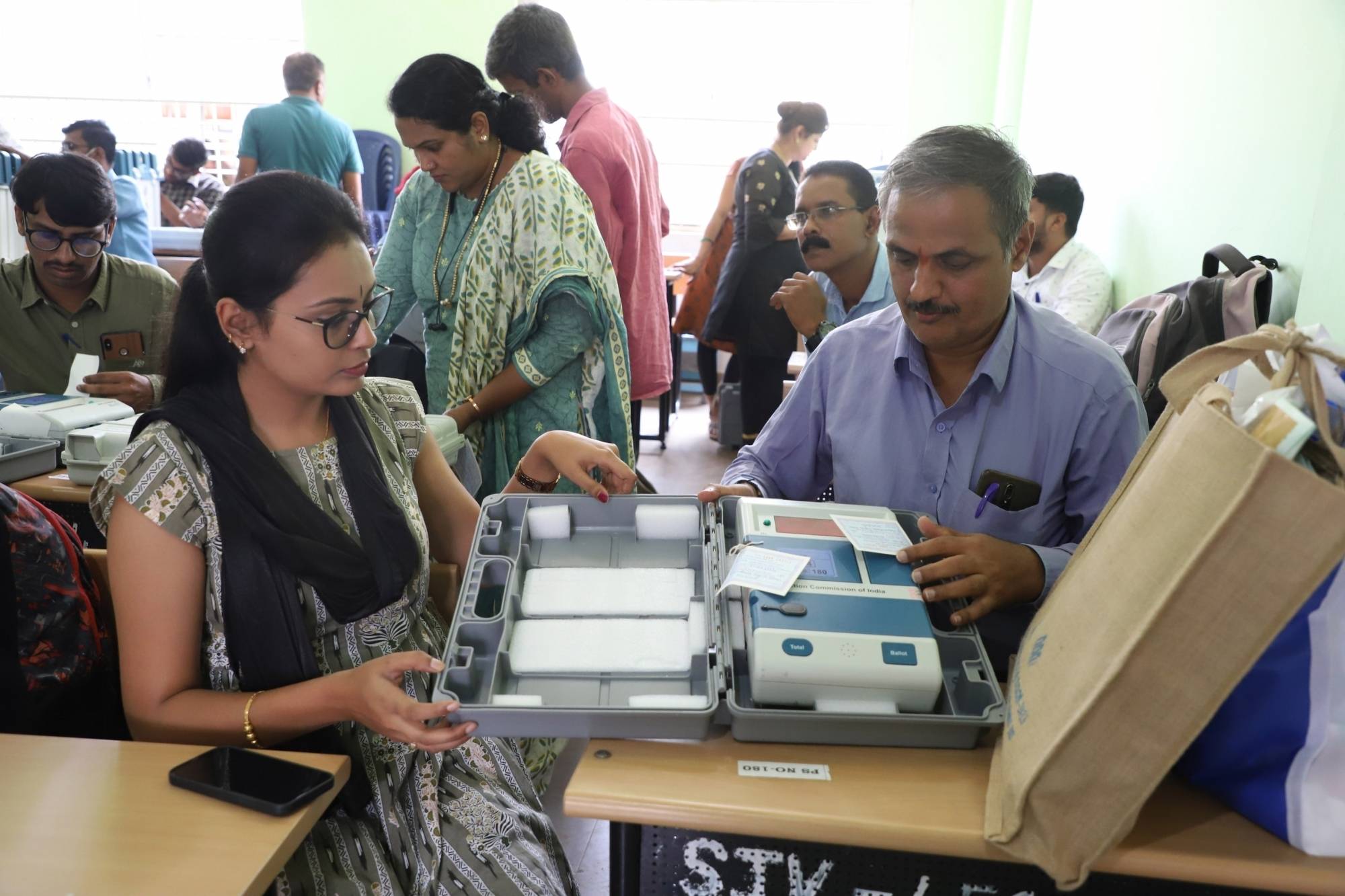 Bengaluru: Polling officials collect EVMs and other voting materials ahead of the Karnataka Assembly elections, at Veterinary College distribution centre in Bengaluru, Tuesday, May 9, 2023 (Photo:IANS)